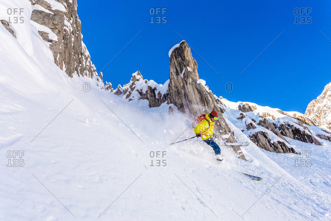 A skier on a steep rocky mountain slope in St Anton, Austria