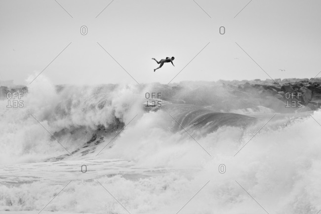 Surfer launching from large wave in California