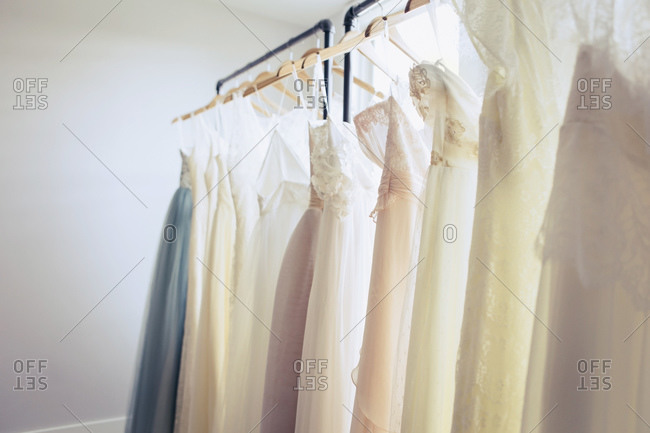 White and pastel colored wedding dresses on rack