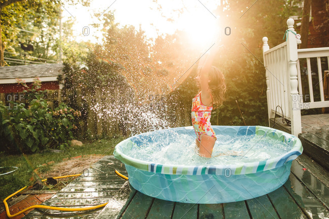 Little girl splashing in a kiddie pool