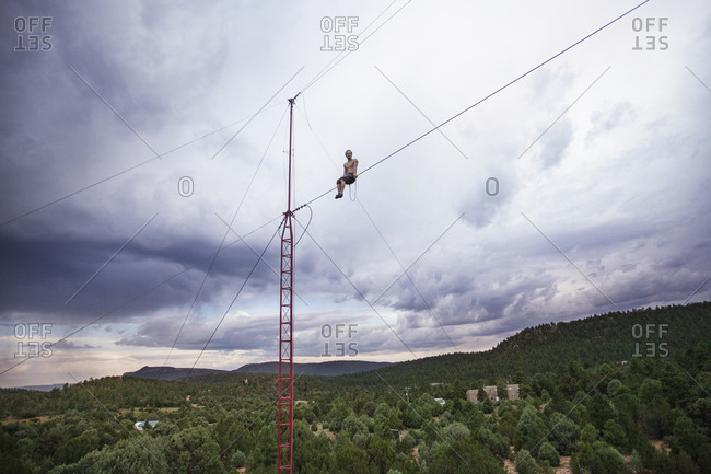 Tightrope walker sitting on tightrope