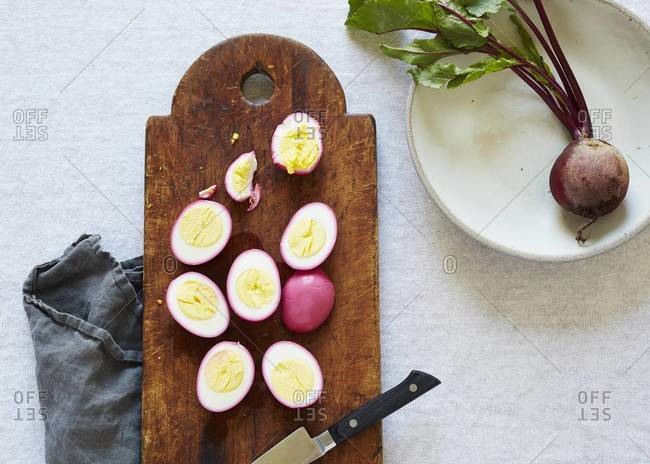 Beet pickled eggs on a cutting board