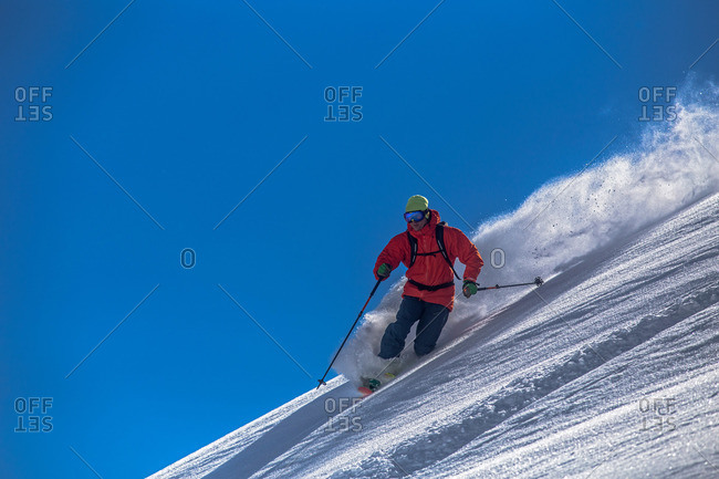 Man skiing steep mountain in winter