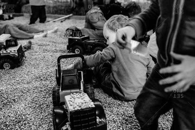 Children playing with trucks in a corn kernel box