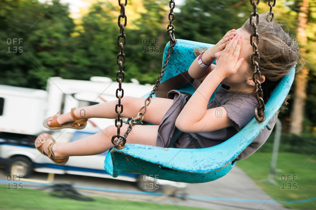 Girl closing her eyes on a swing ride at a fair