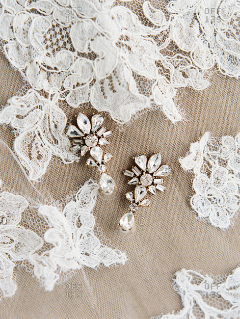 Close-up of vintage style earrings on lace wedding veil