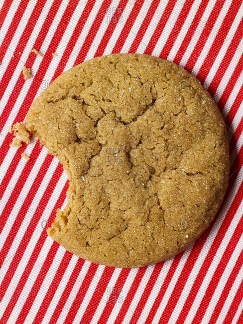 Bitten ginger cookie on a red and white striped background