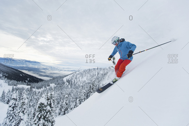 Mature man skiing down a steep slope