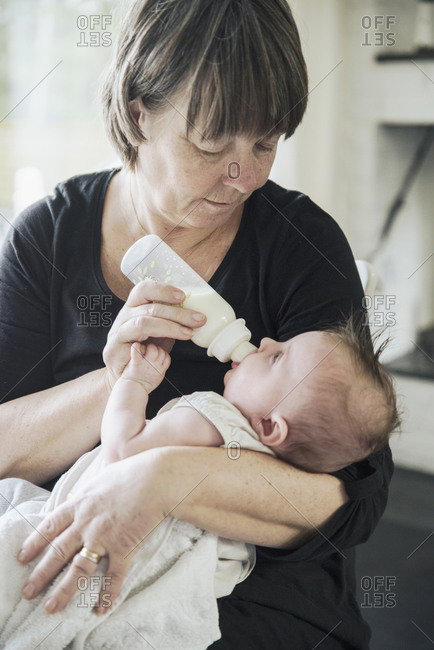 Grandmother bottle feeding baby