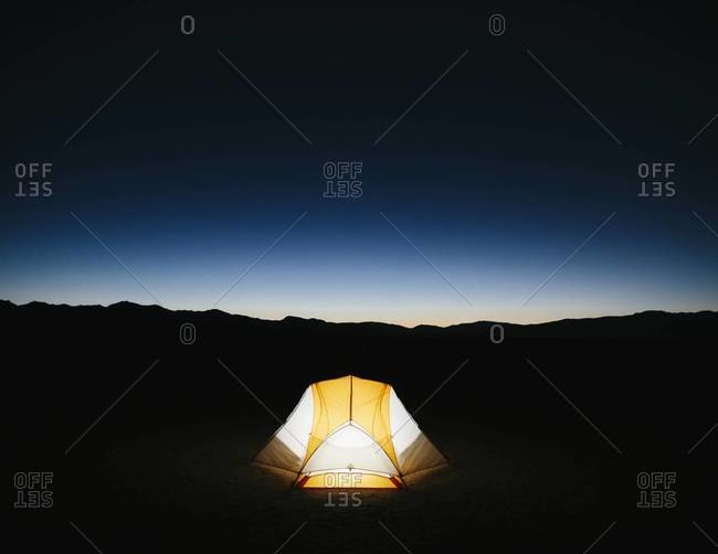 Illuminated camping tent in Black Rock Desert, Nevada at night
