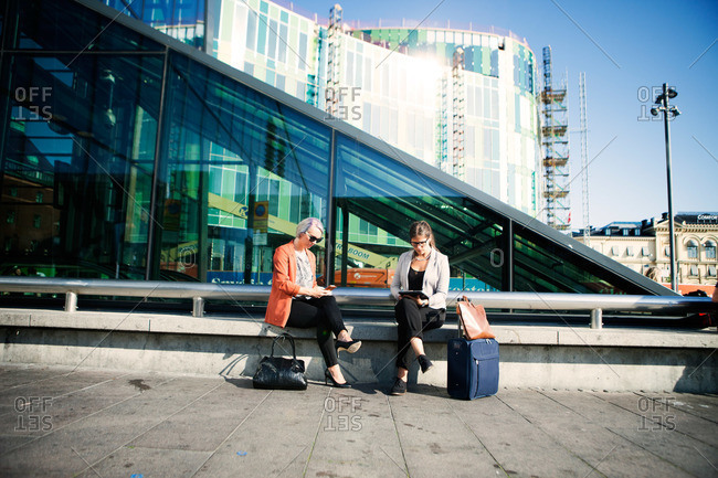Travelers with mobile devices at a train station in Malmo, Sweden