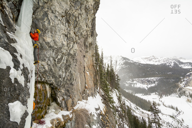 A man and woman ice climbing a frozen waterfall called The Talisman along the Camp Bird Road near Ouray, Colorado