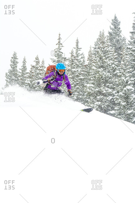 A woman backcountry skiing on a snowy day above Red Mountain Pass in the  Uncompahgre National Forest, Silverton, Colorado