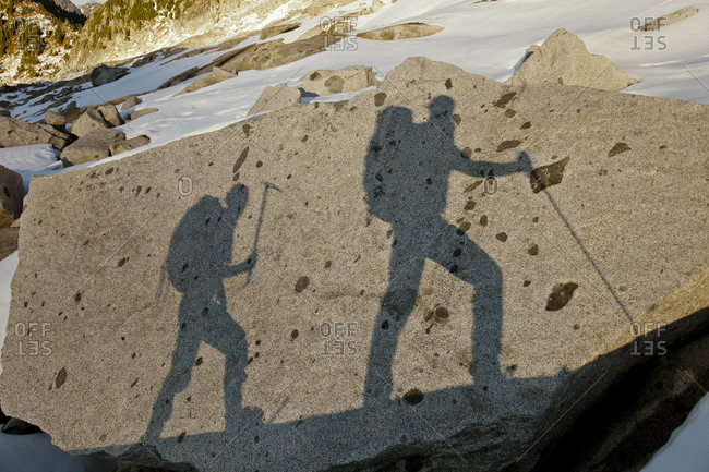 The shadows of two backpackers on a large rock en route Conway Peak, British Columbia, Canada