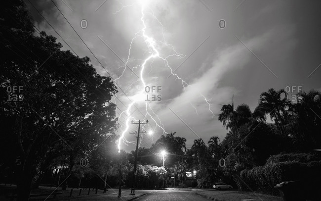 Huge bolt of lightning strikes in a tropical neighborhood