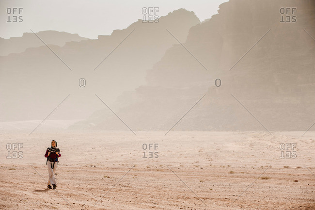 Woman hiking through desert scenery, Wadi Rum, Jordan, Middle East