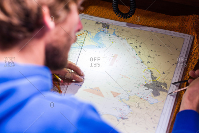 Skipper planning a route on a nautical chart at a sailing boat, Pula, Istria, Croatia