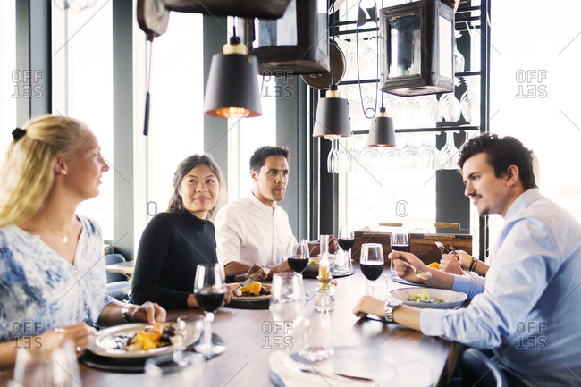 Group of people eating dinner together at a restaurant