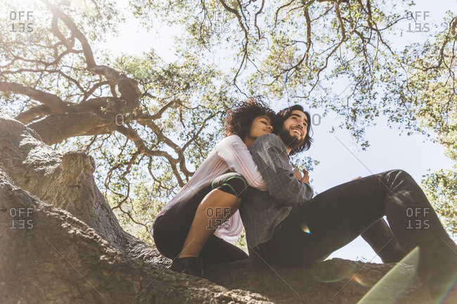 Young couple with arms around each other in a tree