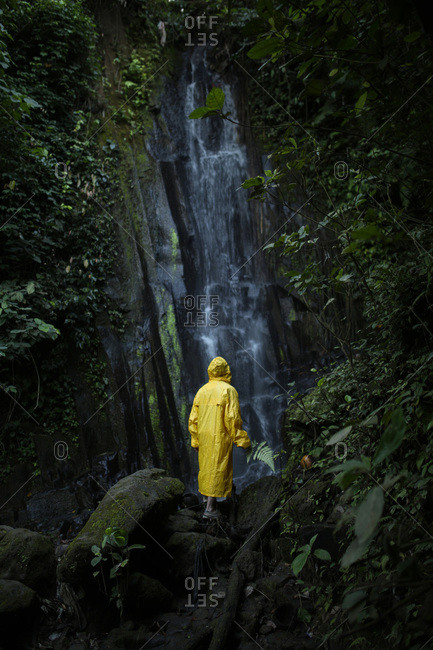 Man in a yellow raincoat hiking in a forest
