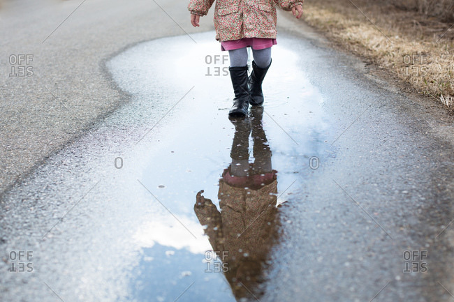 Girl walking through a puddle