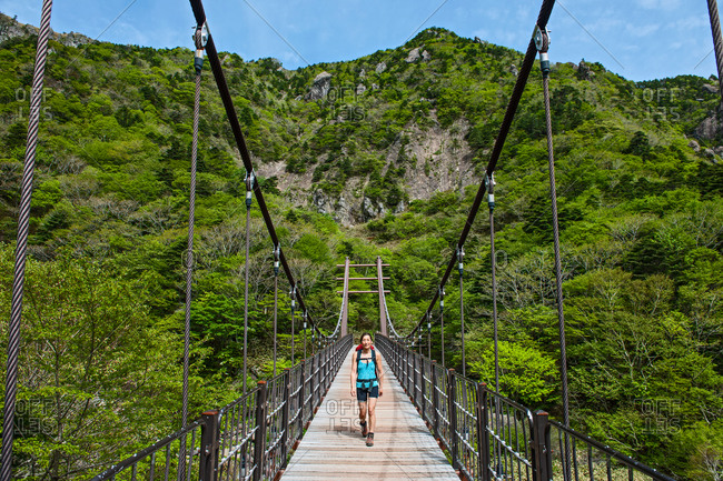 Walking across a bridge on the Gwaneumsa hiking trail to Hallasan on Jeju Island