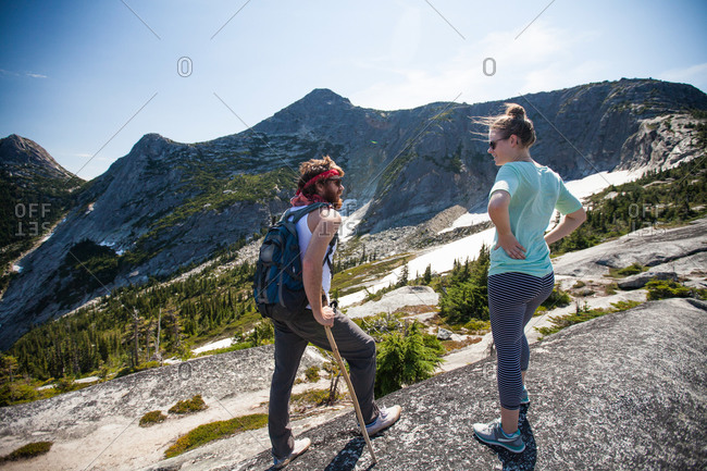 Two backpackers stop to converse while hiking toward Needle Peak, British Columbia, Canada