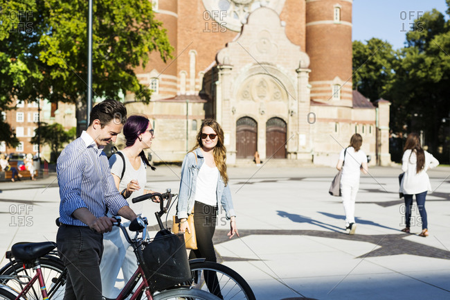 Three young people walking in front of St. Johannes Church in Malmo, Sweden
