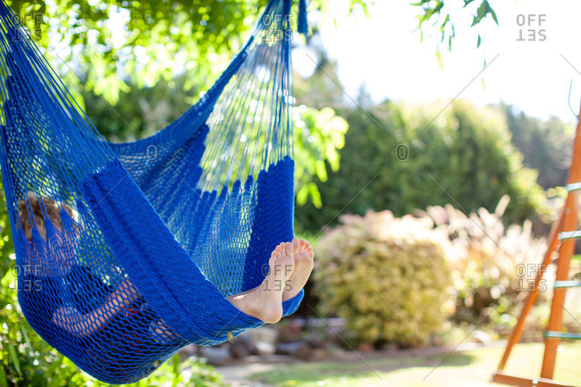 Boy lounging in a hammock in his yard