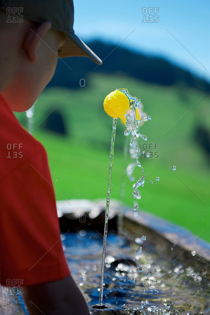 Boy playing with a small ball at fountain