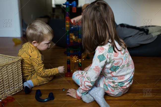 Boy and girl playing with stacking chute toy