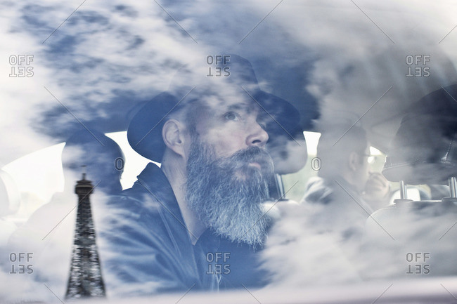 Bearded man staring at Eiffel Tower in cab