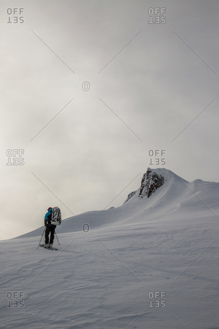 A skier ascends a steep peak during the Spearhead Traverse in the Coast Mountains of British Columbia, Canada