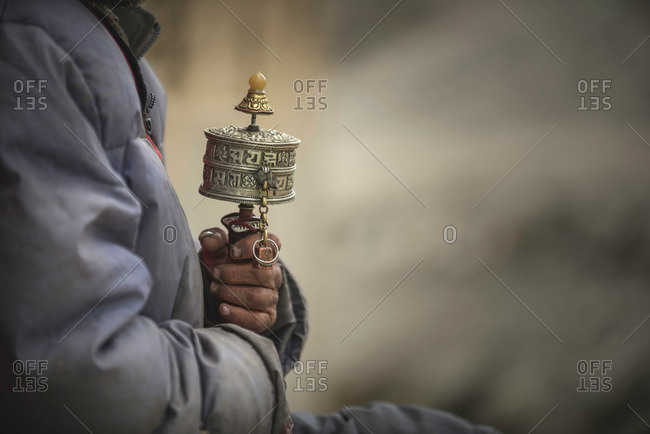 Person holding prayer wheel in rural India