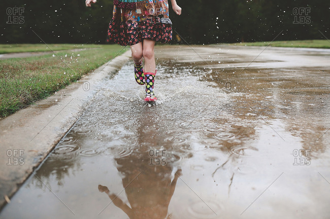 Feet of girl splashing through puddle
