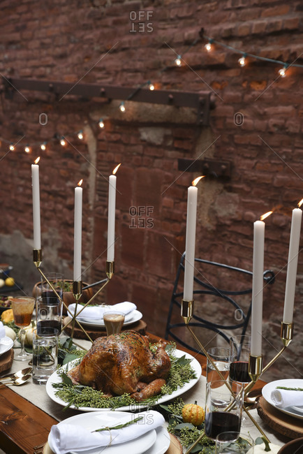 Candle lit turkey dinner by brick wall