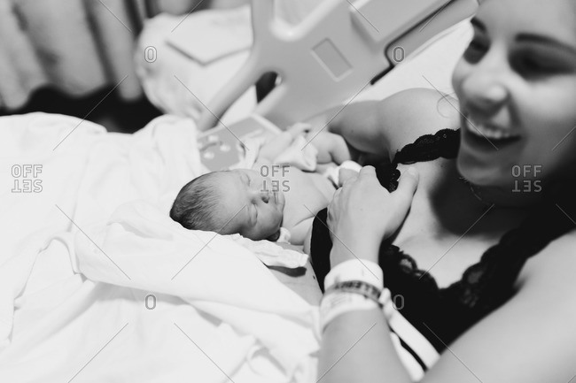 New mother holding her baby girl in a hospital bed