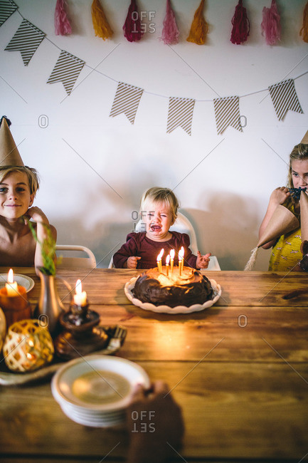 Toddler girl crying at birthday celebration