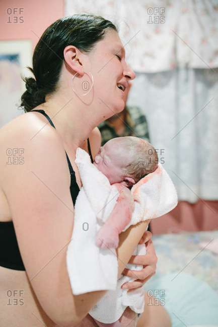 A woman holds her child right after giving birth