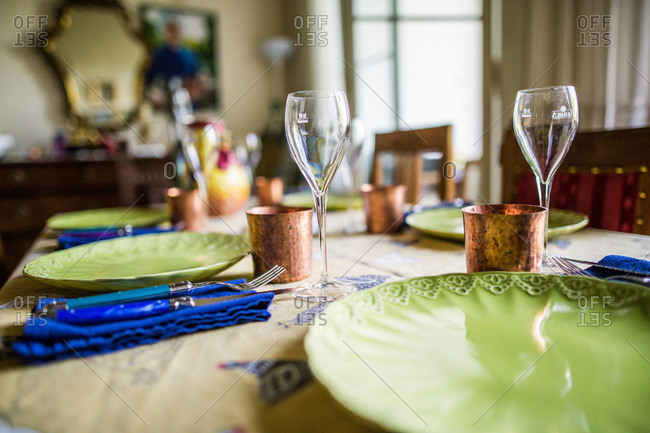 Table set with dishes, wine glass and copper cup for a meal