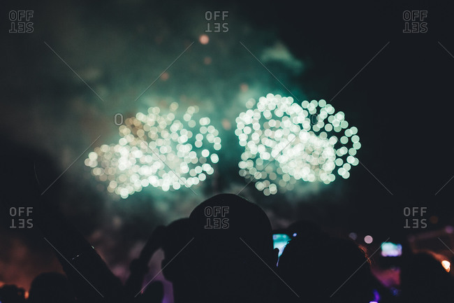 Crowd silhouetted by fireworks