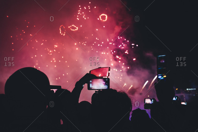 Crowd silhouetted by firework display
