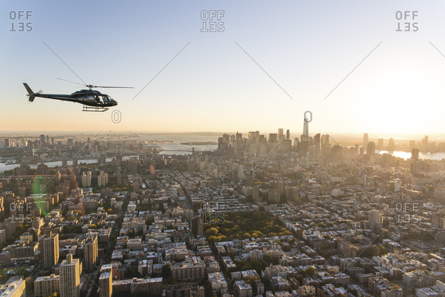 Helicopter flying over the island of Manhattan at sunset, New York City, NY
