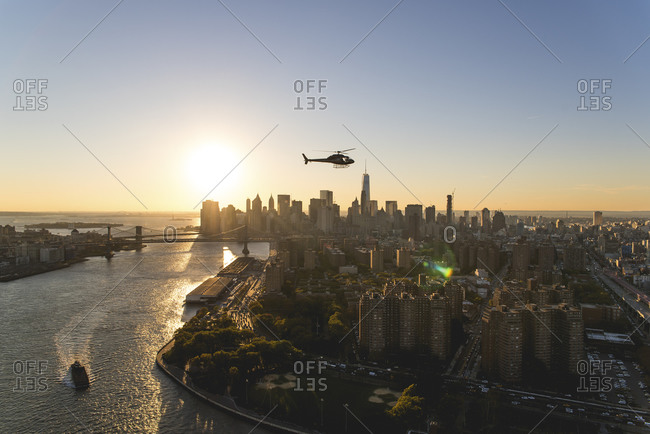 Helicopter flying over Manhattan at sunset, New York City, NY