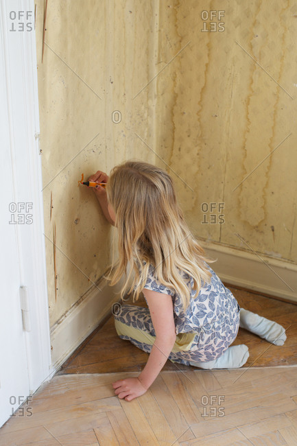 Little girl drawing on wall using marker pen