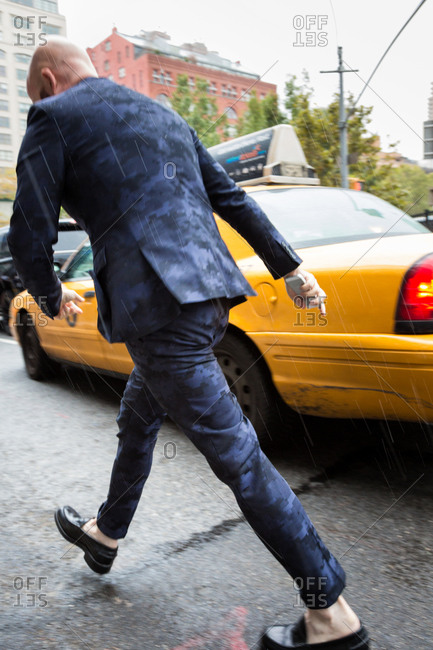 Man in a designer suit walking in the rain