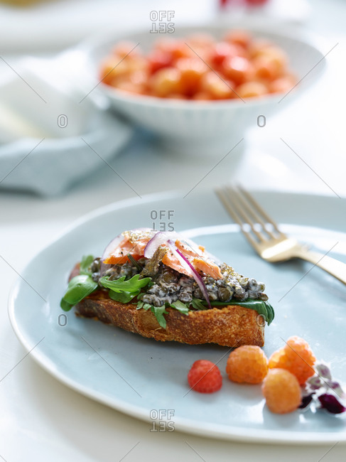 Plate with salmon appetizer and white raspberries