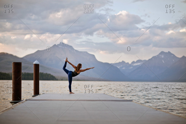 A woman does yoga on a dock in Glacier National Park, Montana