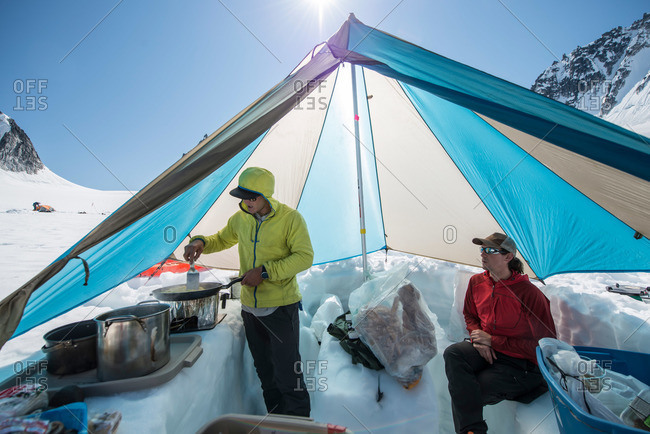 A man makes breakfast in a cook tent on a Glacier in Little Switzerland in the Alaska Range