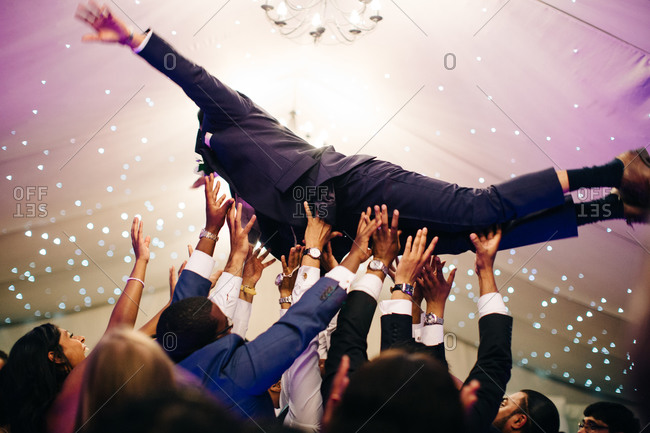 Wedding guests catch groom as he dives into crowd